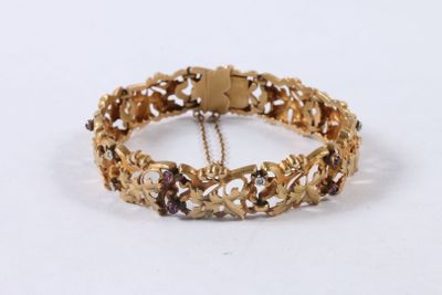 bracelet en or orné de grenats et d'une chaîne, sur fond blanc