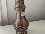 a silver vase sitting on a table with a tag on it