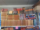 une grande pile de livres posée sur une étagère dans une pièce