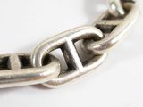 a close up of a silver chain on a white surface