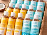 a basket filled with lots of bottles of bath products on top of a wooden table