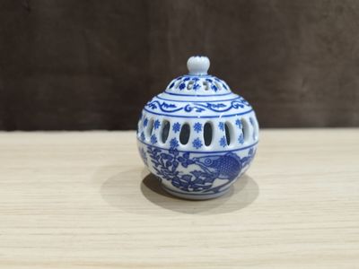 un petit vase bleu et blanc posé sur une table