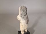 an old statue of a woman with a hat on her head