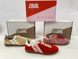 trois paires de chaussures en toile de couleurs et de pointures différentes, posées devant une boîte