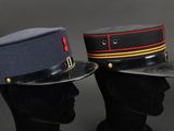 two military hats on a mannequin head on a black background