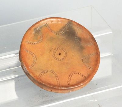 un petit objet marron exposé dans une vitrine