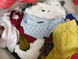 une pile de vêtements dans un panier sur le sol
