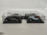two model cars in a display case on a table