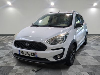La Ford Kad blanche est garée dans une pièce au sol carrelé en damier.