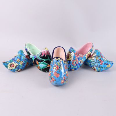 three pairs of clogs with colorful floral designs on them