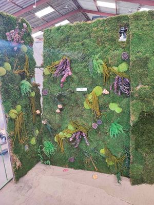 a room with a wall covered in fake grass and plants