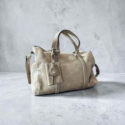 une photo d'un sac à main beige posé sur une table