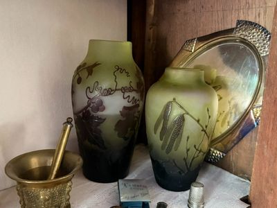 two vases sitting on a shelf next to a mirror