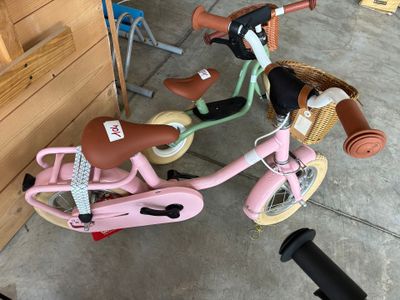 un petit vélo rose avec un panier à l'arrière