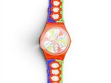 a watch with a flower design on it on a white surface