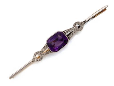 un gros plan sur une broche composée d'une pierre violette et de diamants