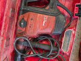 a red tool box with a drill and a cord in it