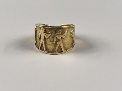 un gros plan d'une bague en or sur laquelle sont gravés un homme et une femme