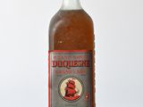 des bouteilles d'alcool posées sur une table en bois, sur fond blanc
