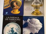 quatre livres posés sur une table, avec un vase posé dessus