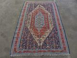 un tapis oriental posé au sol, orné d'un motif bleu et rouge