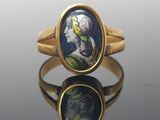 un gros plan d'une bague en or sur laquelle figure le portrait d'une femme