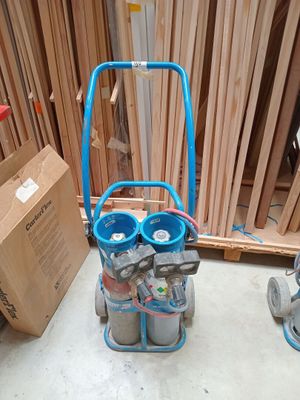 un chariot bleu sur lequel se trouvent deux bouteilles, à côté d'une caisse en bois