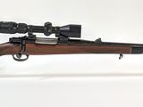 le fusil repose sur un support transparent équipé d'une lunette de visée