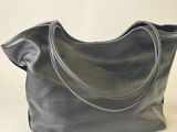 the large grey leather tote bag is on a white background