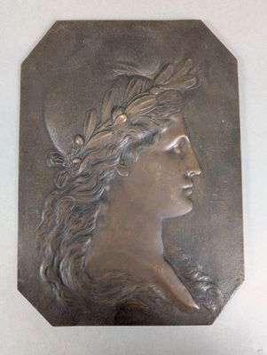 a picture of a bronze plaque of a woman with a wreath on her head