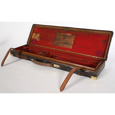 une vieille valise ouverte posée sur une surface blanche
