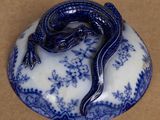 a small blue and white plate with a lizard on it
