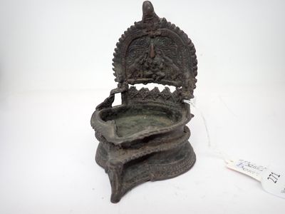 une vieille statue en bronze représentant une personne assise sur une chaise