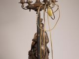 a statue of a man holding a candelab with five candles on it