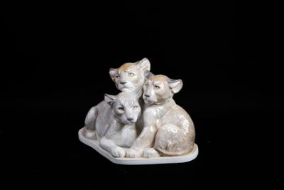 a figurine of a cat and two kittens on a plate