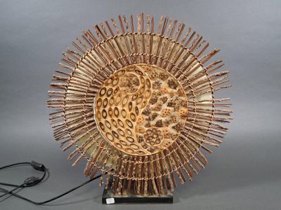 a wooden sculpture of a sunflower on a stand