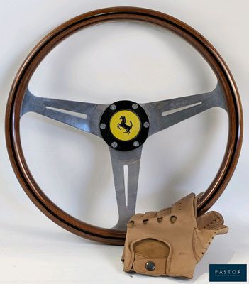 the steering wheel is made of wood and has a leather glove next to it