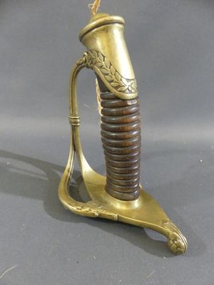 a gold and brown sword that is on a stand