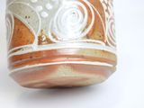 a brown and white vase on a white surface