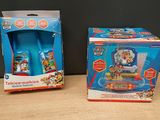 deux boîtes de jouets posées sur une table, sur fond noir