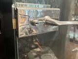 a close up of a metal door handle on a glass door