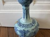 un vase bleu et blanc posé sur un plancher en bois