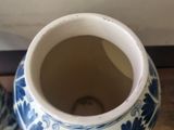 a blue and white vase sitting on the floor next to a white wall
