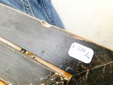 a piece of wood with a sticker on it sitting on someone ' s lap