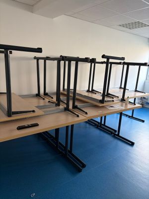 une rangée de pupitres dans une salle au sol bleu