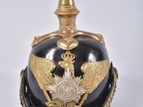 une image représentant un casque noir et doré orné d'un aigle doré
