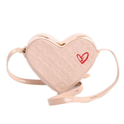 a white heart shaped bag with a red heart on it