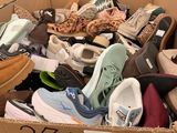 many pairs of shoes in a box on the floor