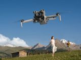 un homme et une femme debout dans un champ, regardant un objet volant