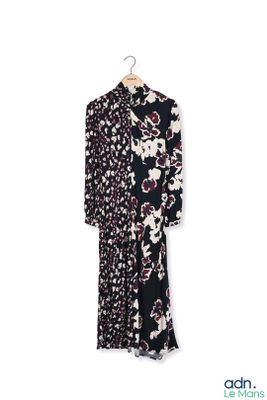 une robe à fleurs noire et blanche suspendue à un cintre sur un mur blanc